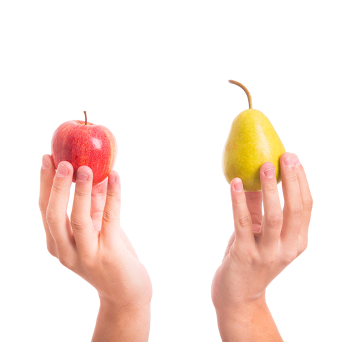 Two hands holding an apple and a pear